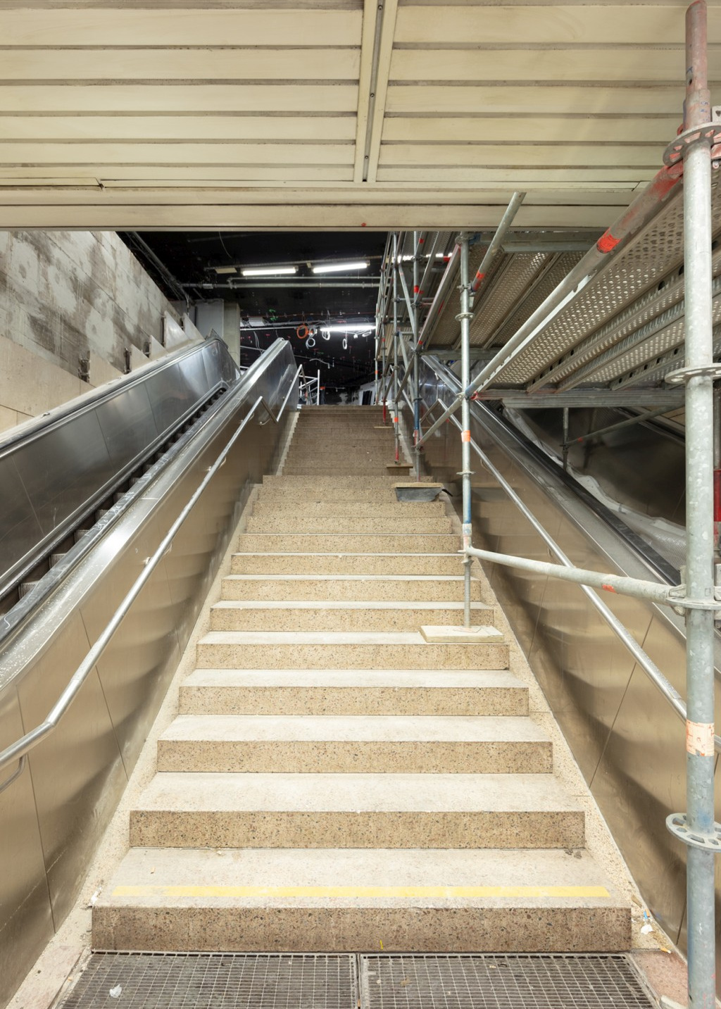 Blick auf den beleuchteten Treppenaufgang und Rolltreppen am Zugang Poststraße