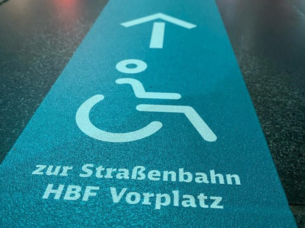 Taktiler Leitstreifen mit der Beschriftung "zur Straßenbahn Hbf Vorplatz"
